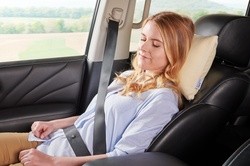 Woman traveling in a car with the Comfort Pillow travel